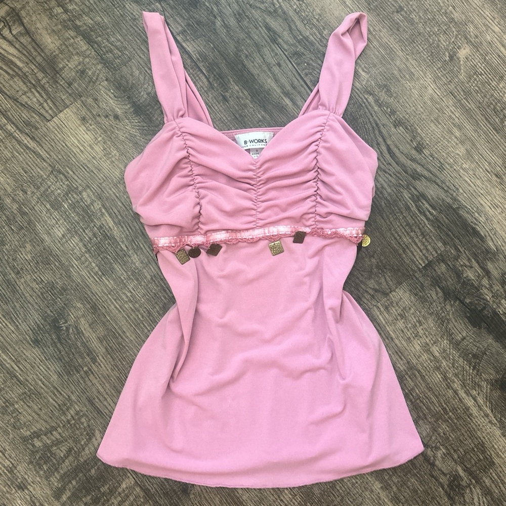 pink tank top with ruffle details and gold charms